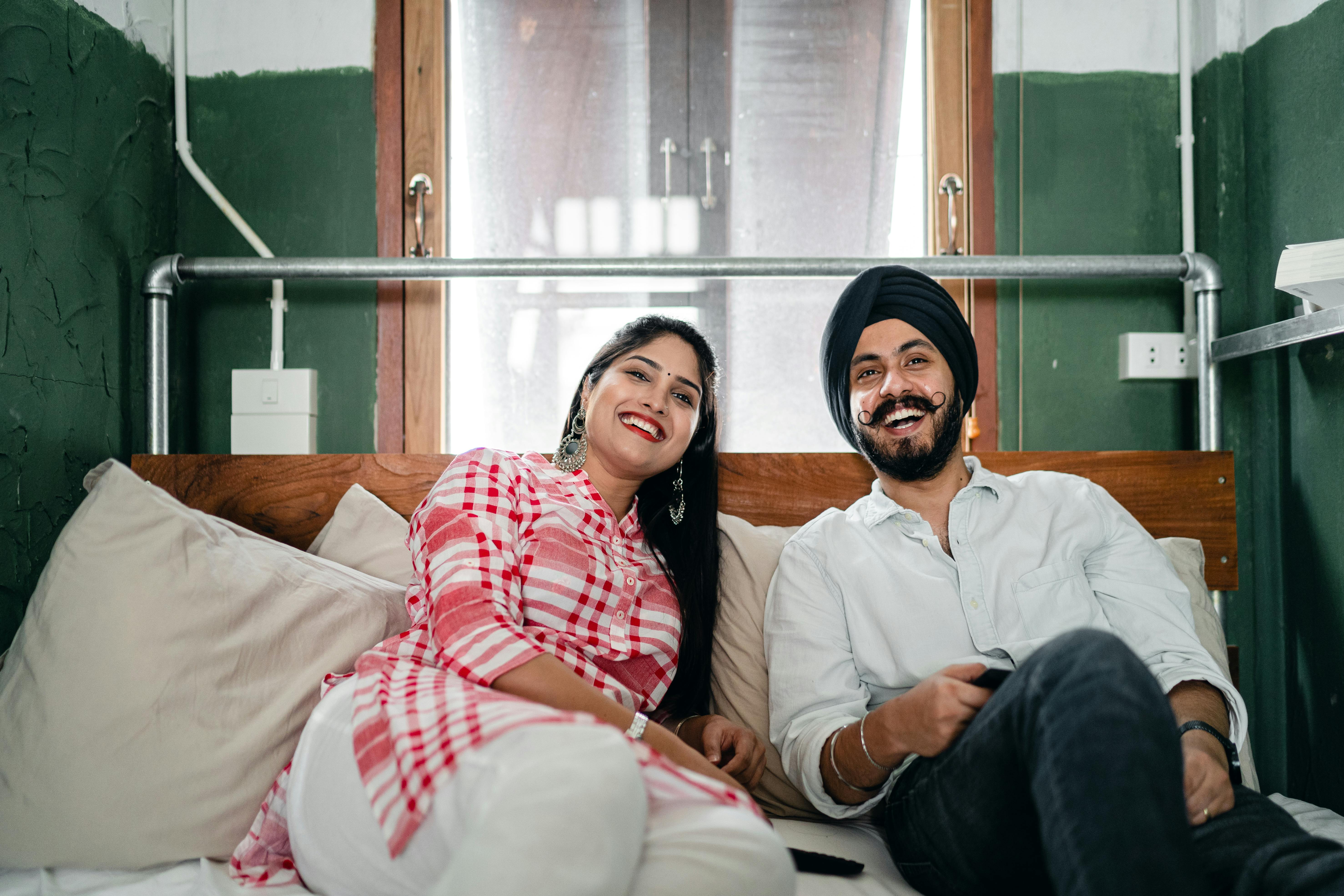 happy ethnic couple relaxing on sofa in living room