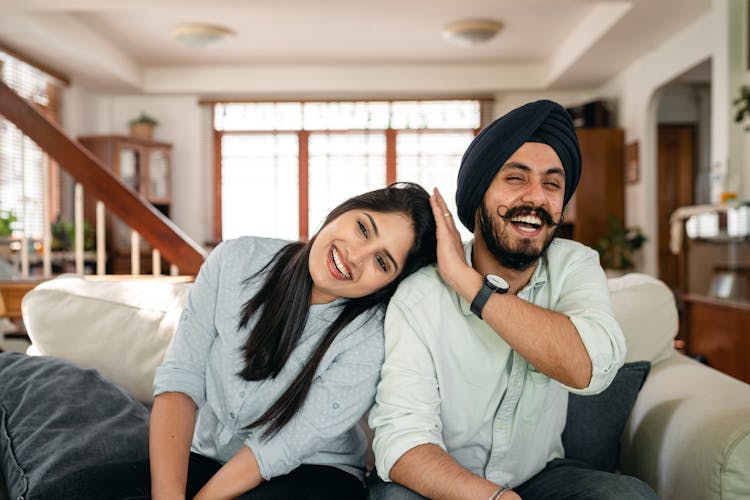 Loving Young Couple Cuddling Happily And Laughing At Home