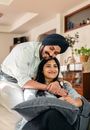 Ethnic glad husband hugging wife from back