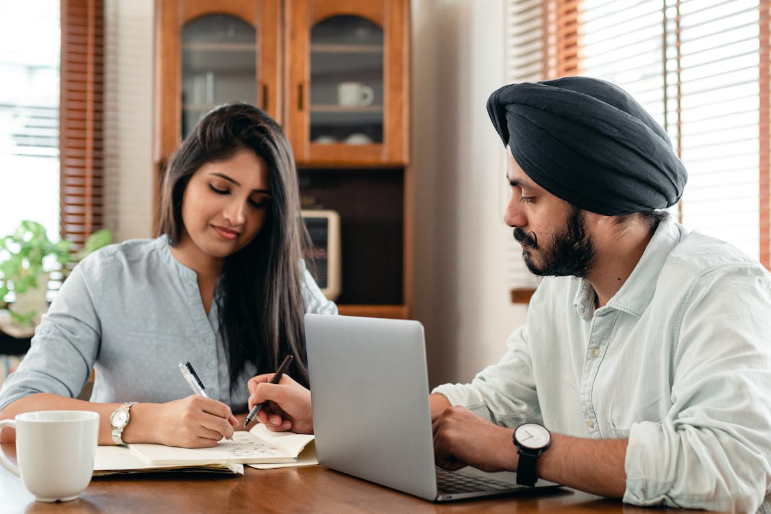 Focused tutor and student doing homework assignment using laptop