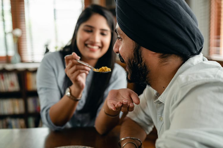 Positive Girlfriend Feeding Crop Indian Boyfriend With Delicious Food