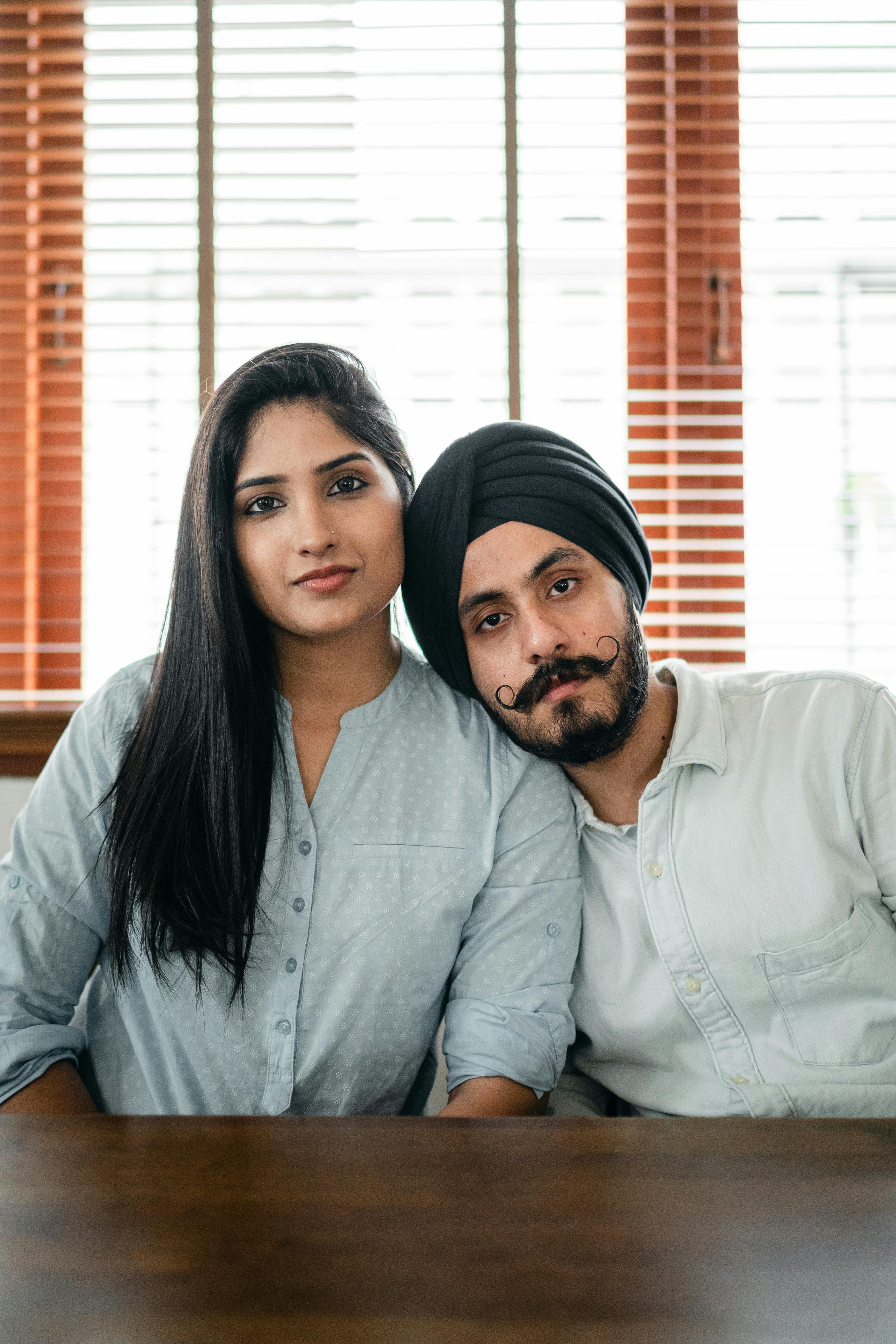 Indian couple embracing at wooden table at home