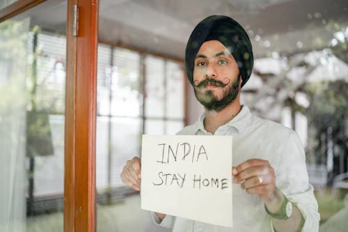 Free Bearded modern Sikh with paper in hands behind glass wall Stock Photo