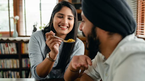 Casal sorridente partilhando arroz de açafrão