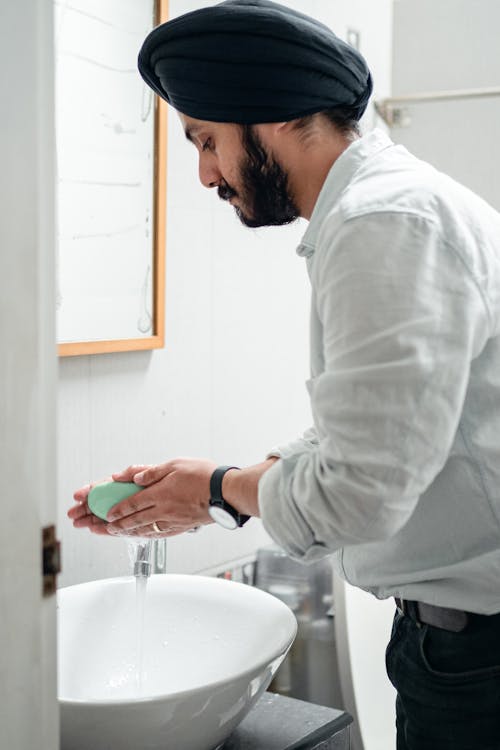 Man in White Dress Shirt Washing his Hands