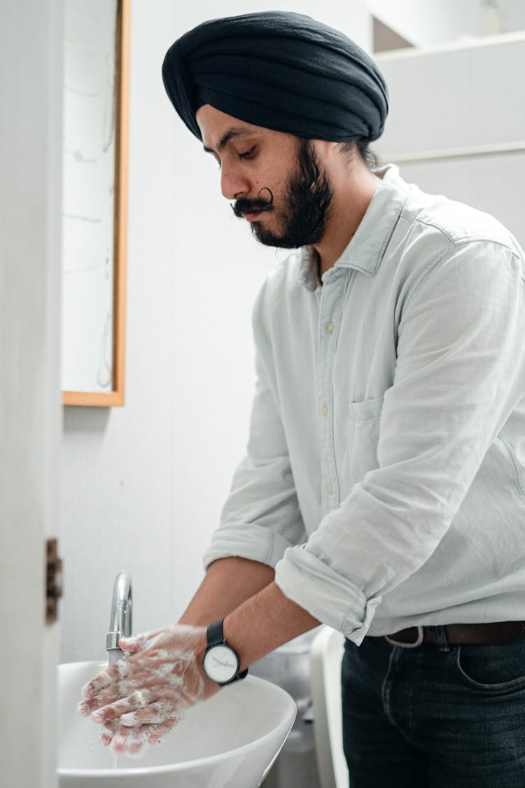 Man In White Long Sleeve Shirt Washing His Hands