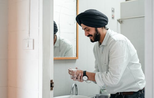 Free Man Washing his Hands in the Bathroom Stock Photo