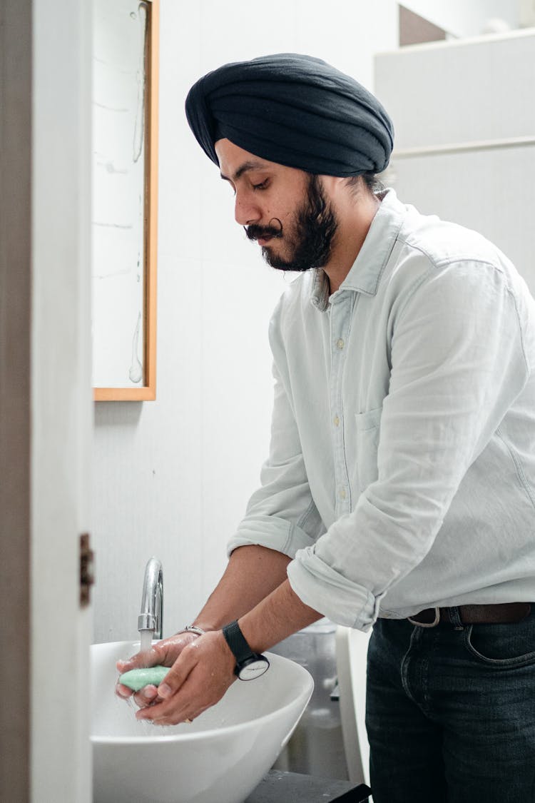 Man Washing His Hands In The Bathroom