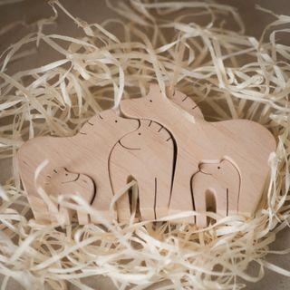 Wooden animal puzzle pieces on wood shavings, photo by Jul Chi on Pexels