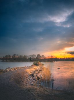 Dramatic sunset view over a tranquil Mörtnäs shoreline in Finland, highlighting nature's beauty.