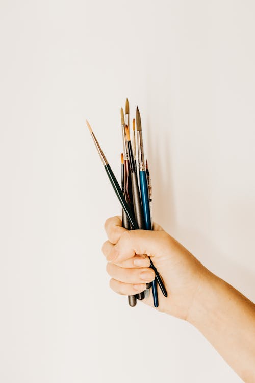 Free Crop artist showing bunch of brushes Stock Photo