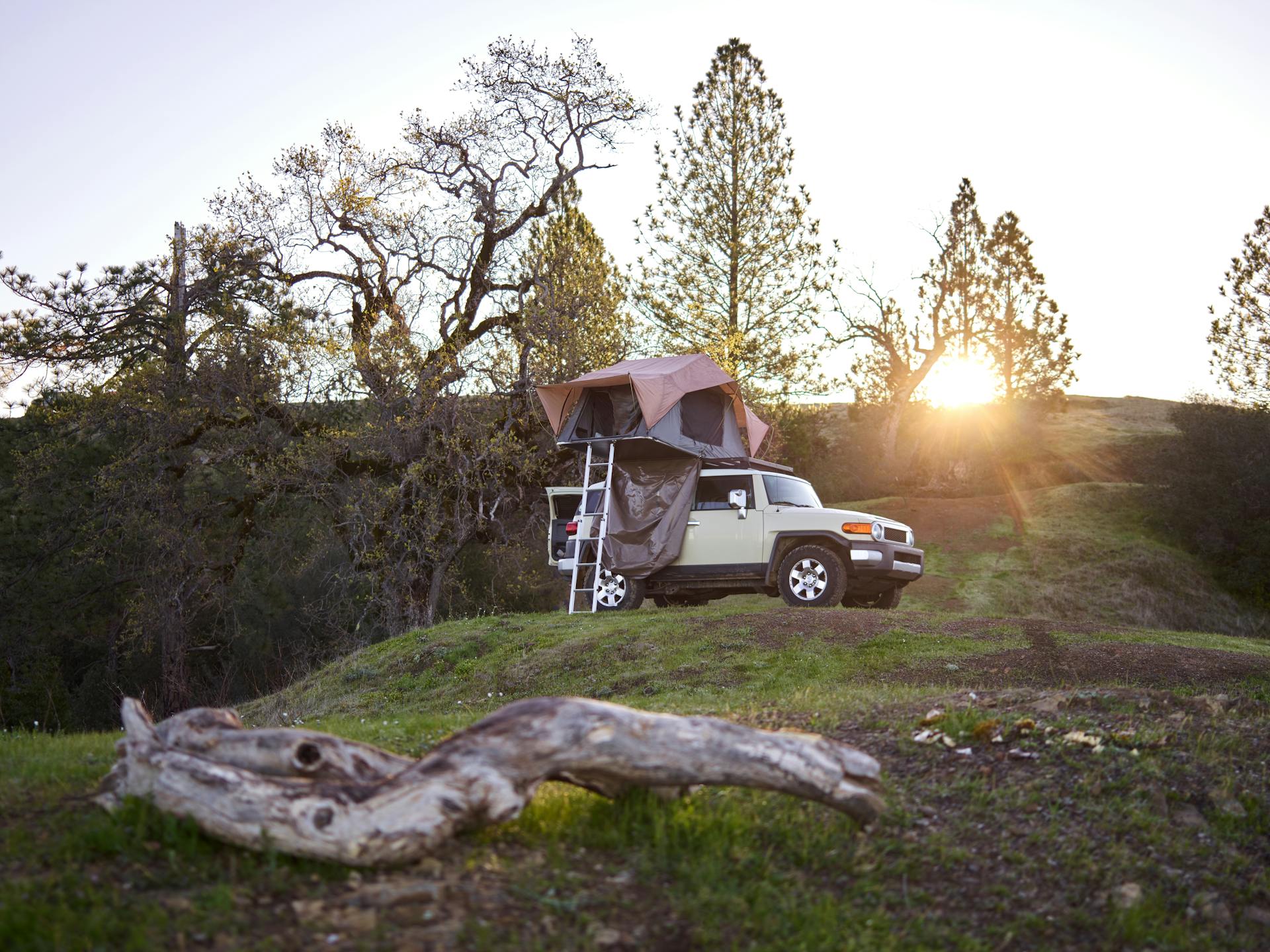 Experience a serene camping evening with a rooftop tent on an SUV in the picturesque wilderness.