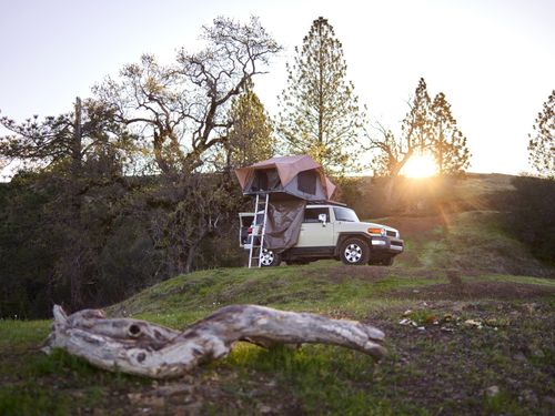 Free Experience a serene camping evening with a rooftop tent on an SUV in the picturesque wilderness. Stock Photo