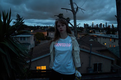 Young woman in white shirt standing on roof