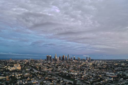 Free Stunning aerial view of Los Angeles skyline at dusk with dramatic clouds overhead. Stock Photo