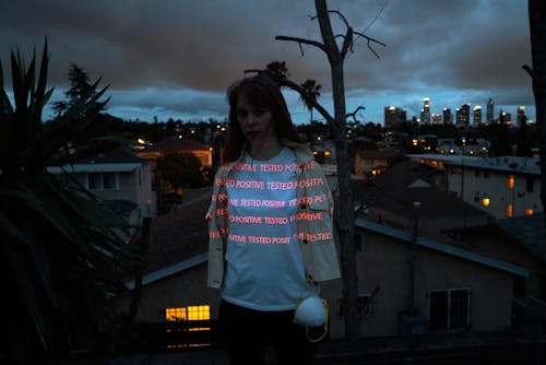 Serious woman on night rooftop with respirator