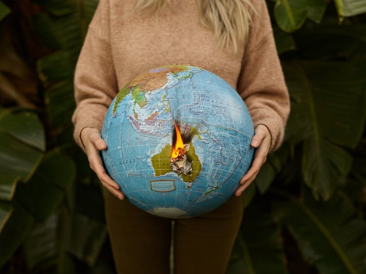 Crop Woman With Burning Globe In Hands