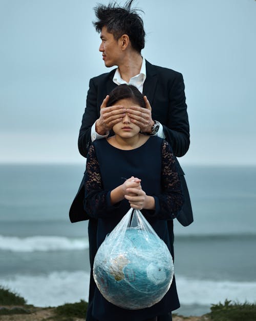 Man and girl with globe in plastic bag