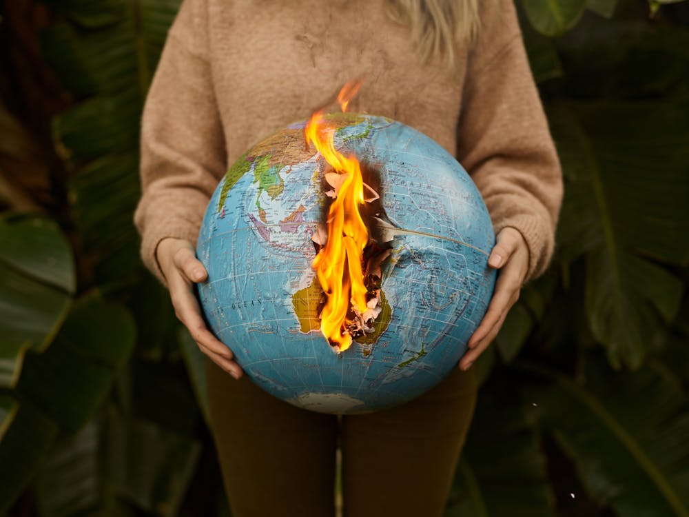 A Person Wearing a Brown Sweater Holding a Burning Globe
