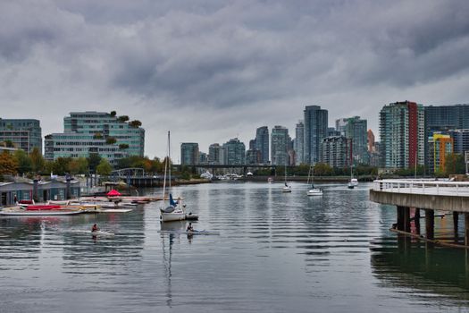 Explore the vibrant skyline of Vancouver, showcasing boats and modern architecture along the calm waters.