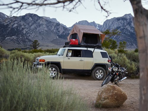 Free A Car with a Rooftop Tent beside a Motorcycle Stock Photo