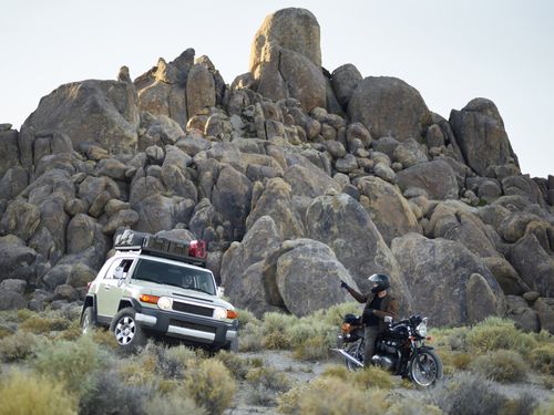 Free Off-road SUV and motorcycle riders exploring rocky desert terrain. Stock Photo