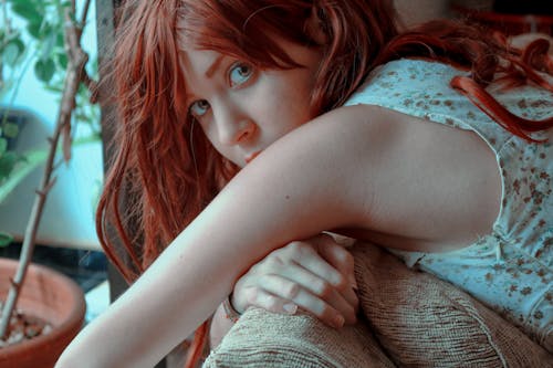 Close-Up Photo of a Woman with Red Hair Looking at the Camera