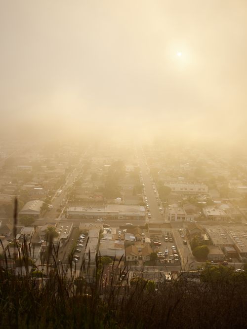 Free Aerial view of thick foggy clouds covering urban district of modern city at sunrise Stock Photo