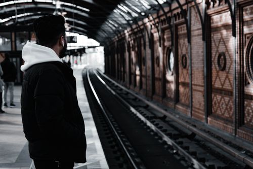 Free Young man waits at Berlin's iconic train station, capturing urban life's essence. Stock Photo