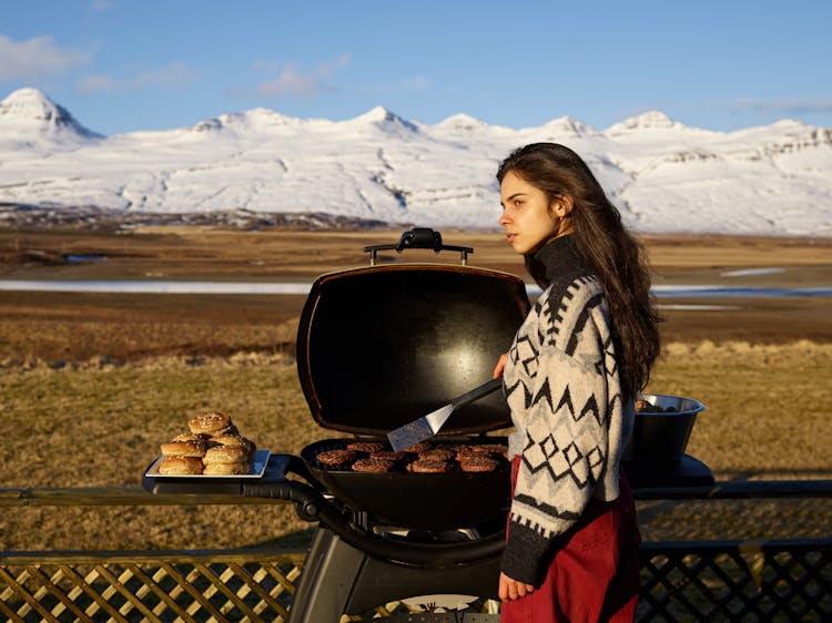 Young Woman Grilling Meat During Winter Holidays