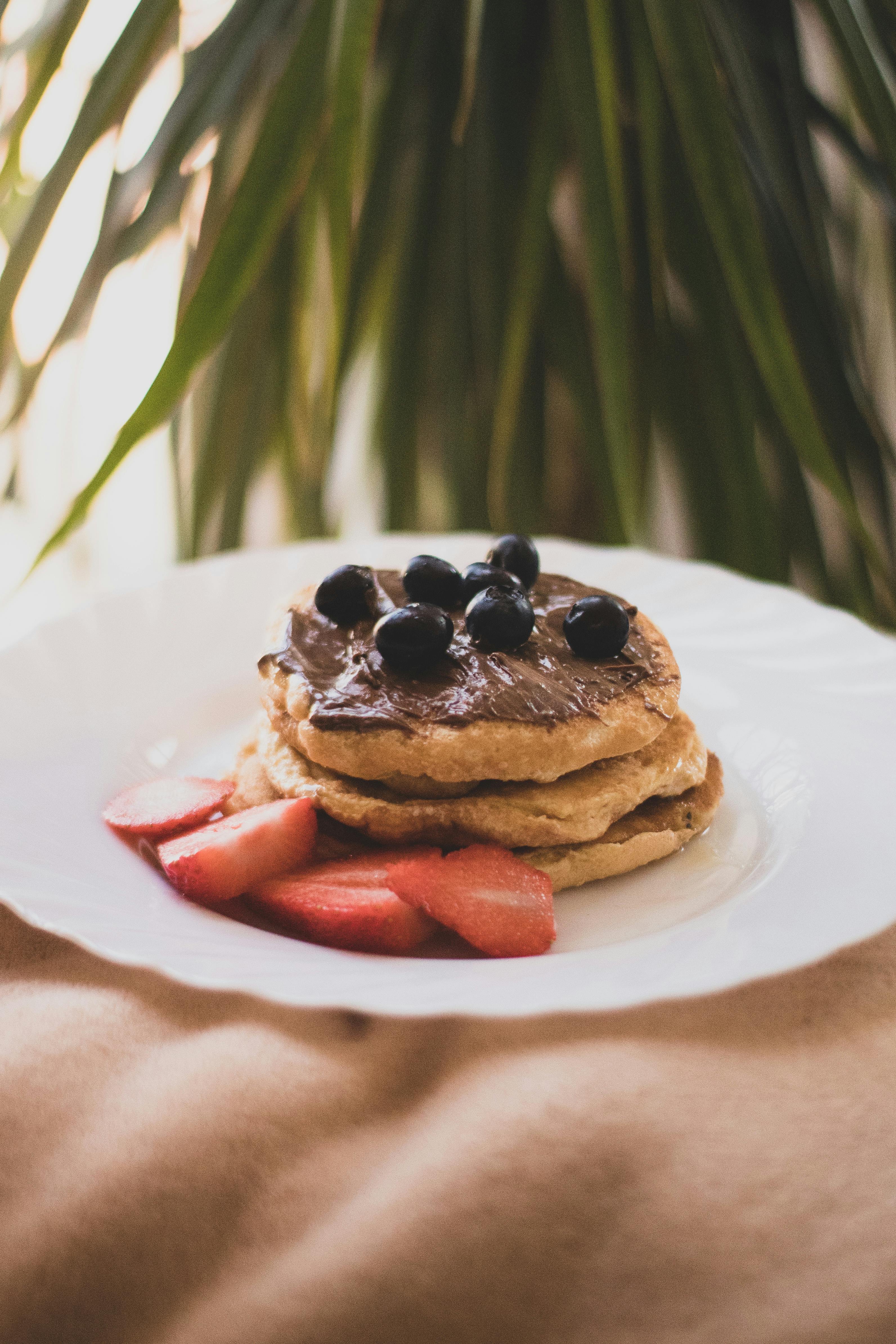 Mouthwatering stack of pancakes topped with chocolate and berries for a perfect dessert.