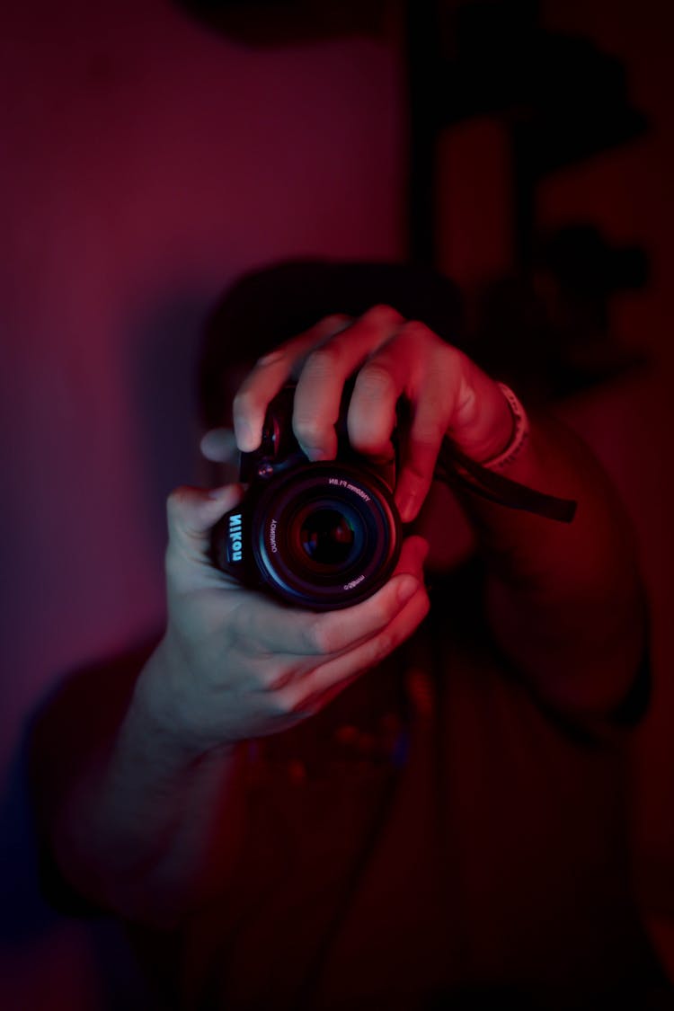 Man With Photo Camera In Dark Studio