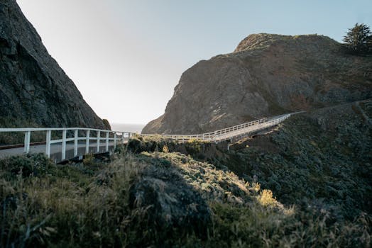 Capture of a serene pathway cutting through rocky hills by the California coast.