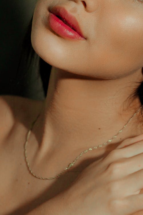 Sensual woman with red lips and accessory on neck