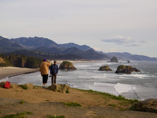 Anonymous travelers enjoying seascape during sundown