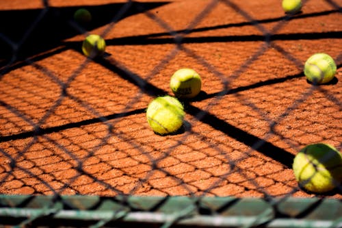 Tennis Balls on Brown Floor