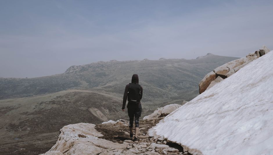 A woman hiking in the rugged terrain of Kosciuszko National Park, Australia.