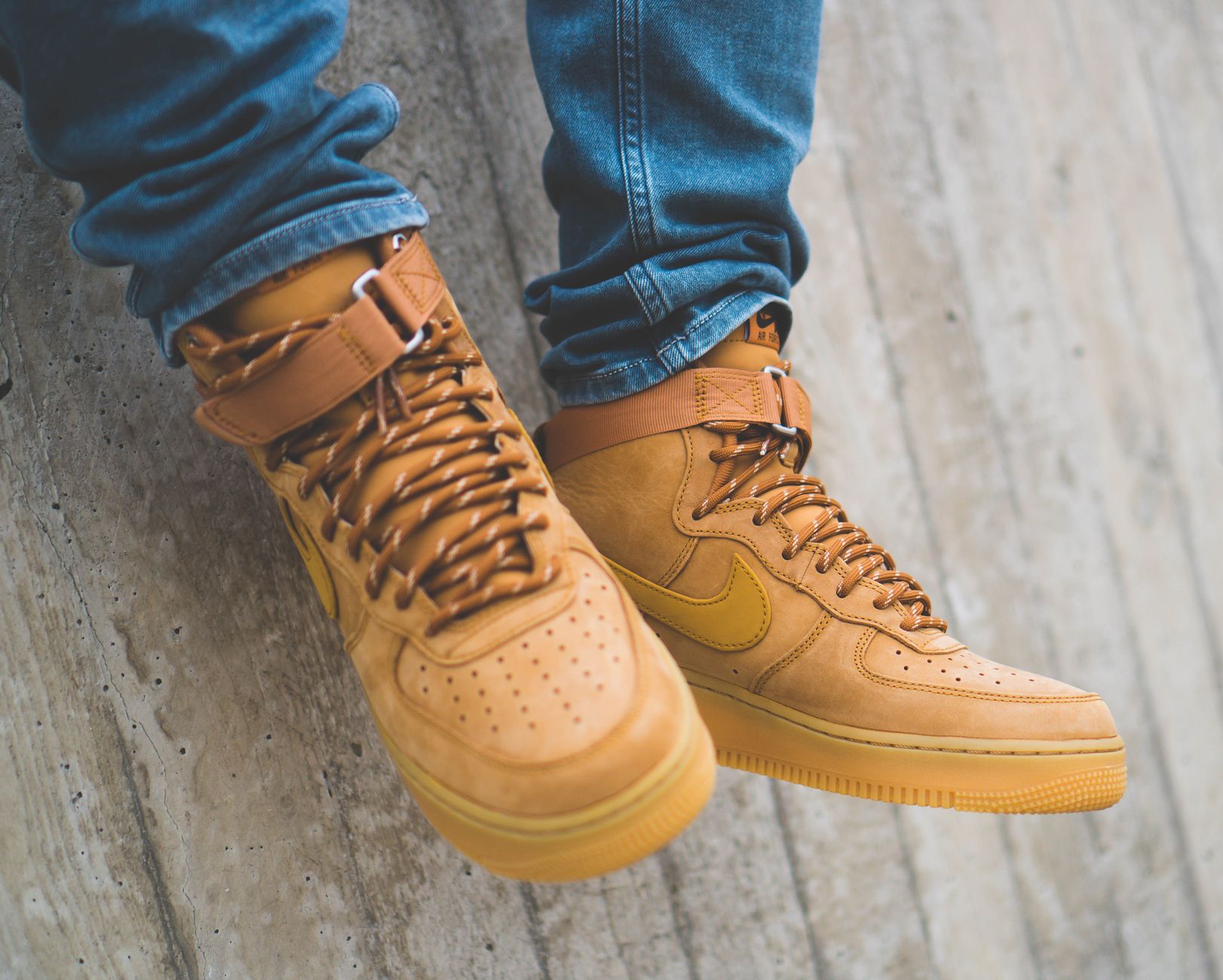 Close-up of brown Nike Air Force sneakers worn with jeans, showcasing urban fashion.