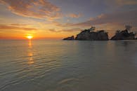 夕阳如田园诗般，绚烂的天空倒映在宁静的海面上