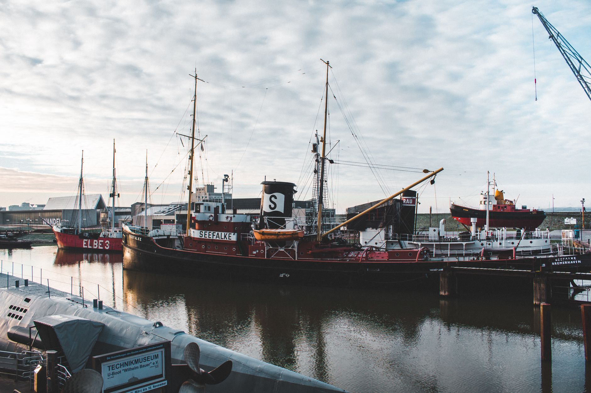 Seefalke and other ships docked at Bremerhaven port under cloudy skies, showcasing maritime history.