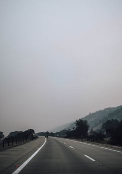 Lonely highway in Australian countryside under gray, overcast sky. Peaceful drive.