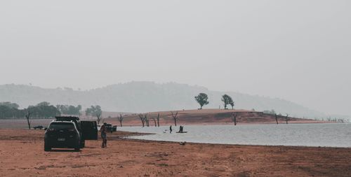 Free Peaceful lakeside scene in Australia with parked vehicles and distant hills. Stock Photo