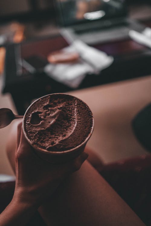 Free Selective Focus Photo of a Person Holding a Cup of Chocolate Ice Cream Stock Photo