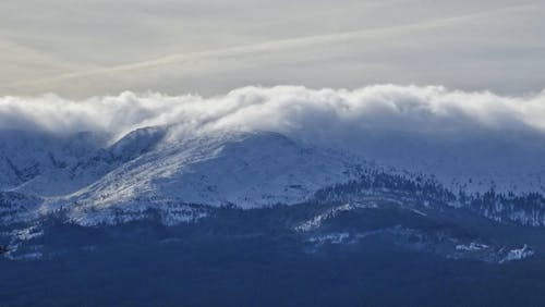 White Clouds over Snow Covered Mountain