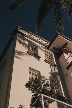 Low angle view of a classic building facade with palm tree shadows, Cremorne, Australia.