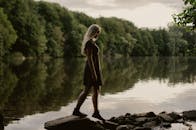 宁静的湖边，茂密的森林环绕，一名年轻女子正享受着安静的时刻