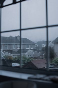 透过雨窗欣赏郊区的房屋，感受到一种阴沉的气氛