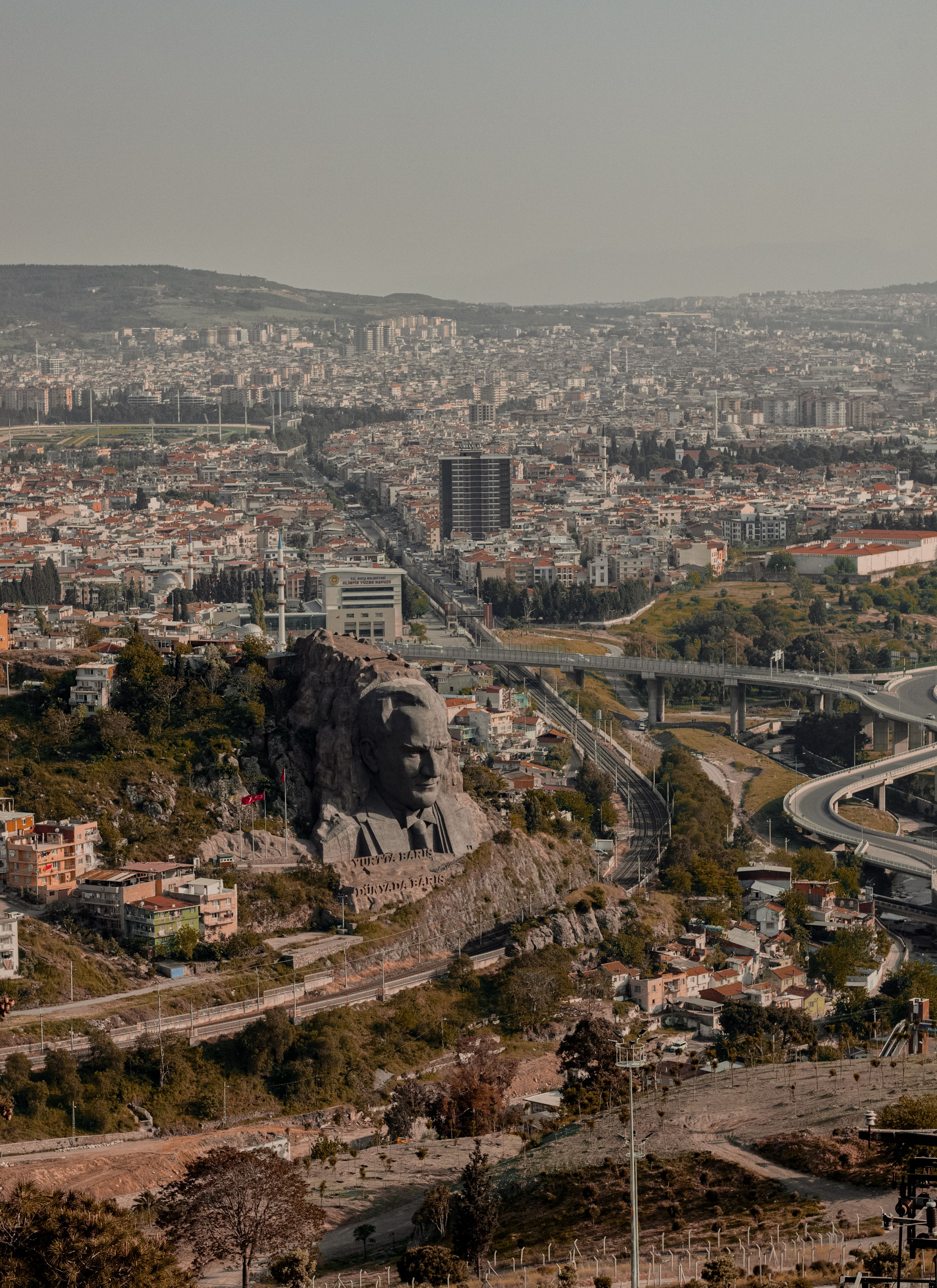 Stunning aerial cityscape of İzmir showcasing the Atatürk monument amid urban sprawl.