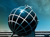 天空晴朗，大型球形结构上停着一架飞机模型