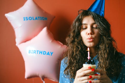 A woman celebrates her birthday with balloons and a candle-lit cupcake, creating a joyful and vibrant atmosphere.